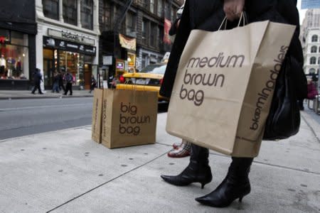 A shopper holds her bags as she tries to hail a cab in New York November 22, 2011.  REUTERS/Jessica Rinaldi