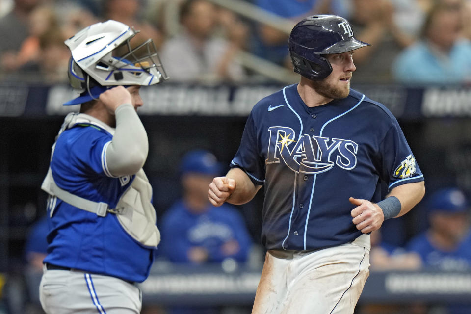 Tampa Bay Rays' Luke Raley, right, scores in front of Toronto Blue Jays catcher Alejandro Kirk on an RBI double by Josh Lowe during the second inning of a baseball game Thursday, May 25, 2023, in St. Petersburg, Fla. (AP Photo/Chris O'Meara)