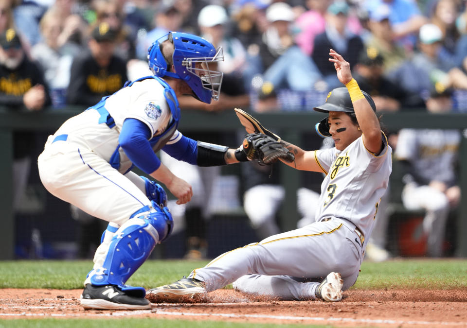 Pittsburgh Pirates' Ji Hwan Bae, right, slides in front of Seattle Mariners catcher Tom Murphy, left, to score on a sacrifice fly by Austin Hedges during the fifth inning of a baseball game Sunday, May 28, 2023, in Seattle. (AP Photo/Lindsey Wasson)