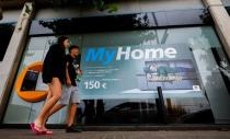 A couple walk past a Caixabank office in Montgat, near Barcelona