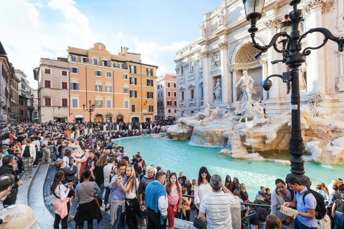 Туристы посещают фонтан Треви в Риме, Италия.