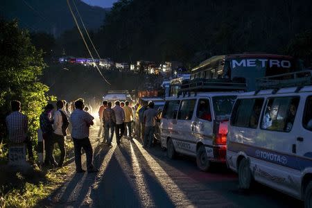 People gather on a road as traffic is affected by a landslide caused by an earthquake, in Kurintar, Nepal April 27, 2015. REUTERS/Athit Perawongmetha