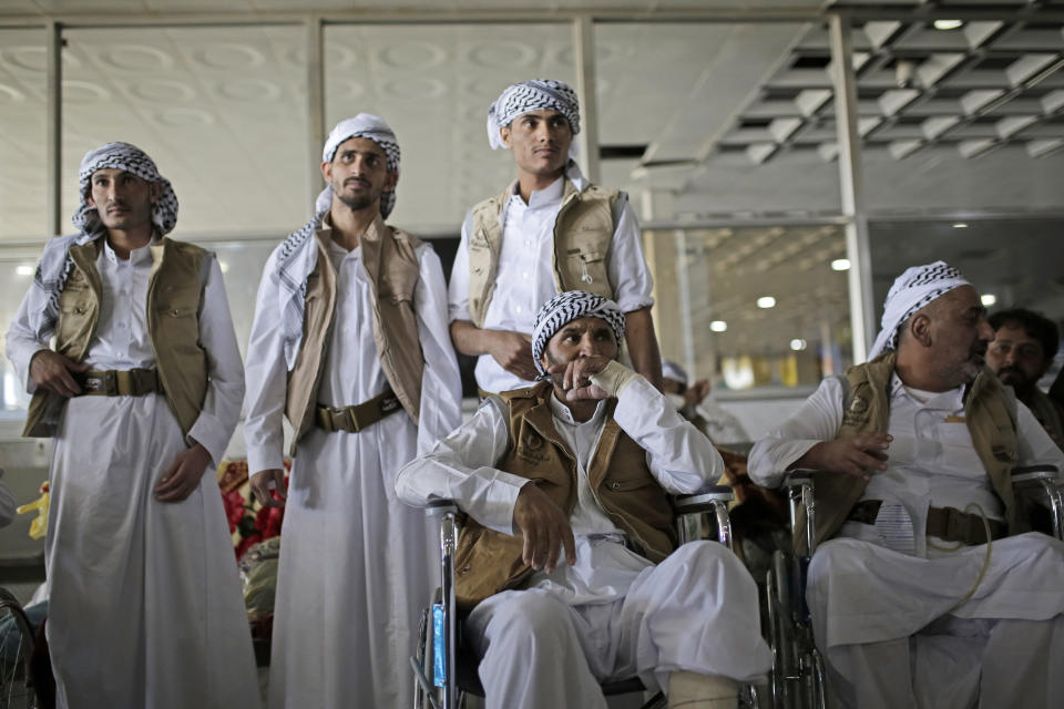 Yemeni prisoners wait for their relatives during their arrival after being released by the Saudi-led coalition in the airport of Sanaa, Yemen, Thursday, Nov. 28, 2019. The International Committee of the Red Cross says over a hundred rebel prisoners released by the Saudi-led coalition have returned to Houthi-controlled territory in Yemen, a step toward a long-anticipated prisoner swap between the warring parties. (AP Photo/Hani Mohammed)