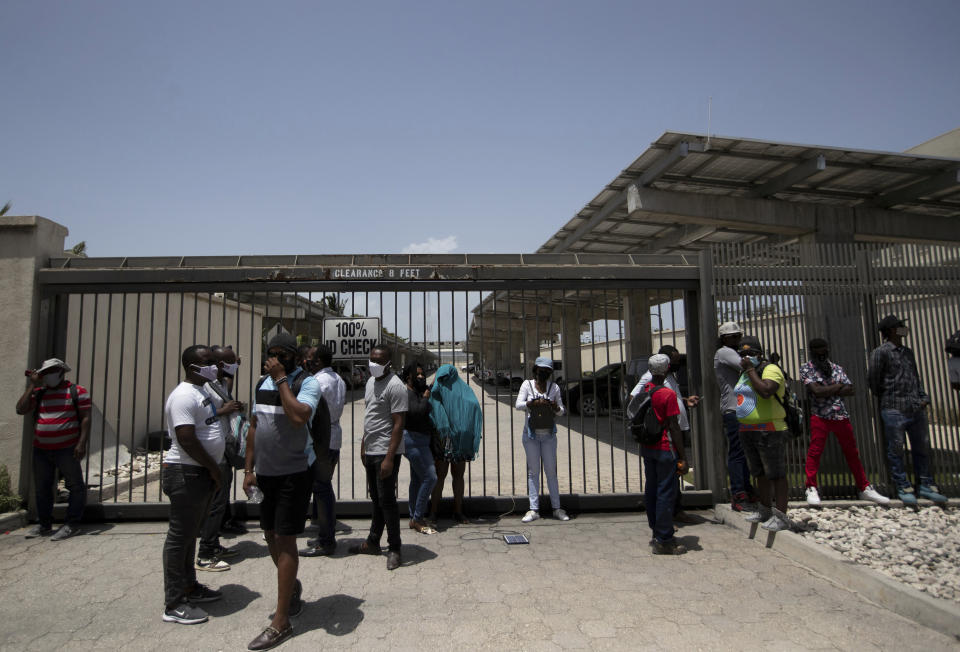 Haitians gather at the main gate of the U.S. Embassy in Port-au-Prince, Haiti, Friday, July 9, 2021. A large crowd gathered outside the embassy amid rumors on radio and social media that the U.S. will be handing out exile and humanitarian visas, two days after Haitian President Jovenel Moïse was assassinated in his home. (AP Photo/Fernando Llano)