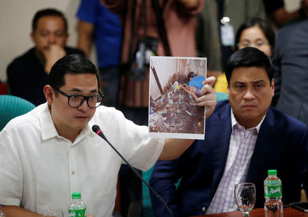 Senator Paolo Benigno Aquino IV holds a photograph of Kian Lloyd Delos Santos during a hearing on the killing of the 17-year-old high school student in a recent police raid, at the Senate headquarters in Pasay city, metro Manila, Philippines August 24, 2017. REUTERS/Dondi Tawatao