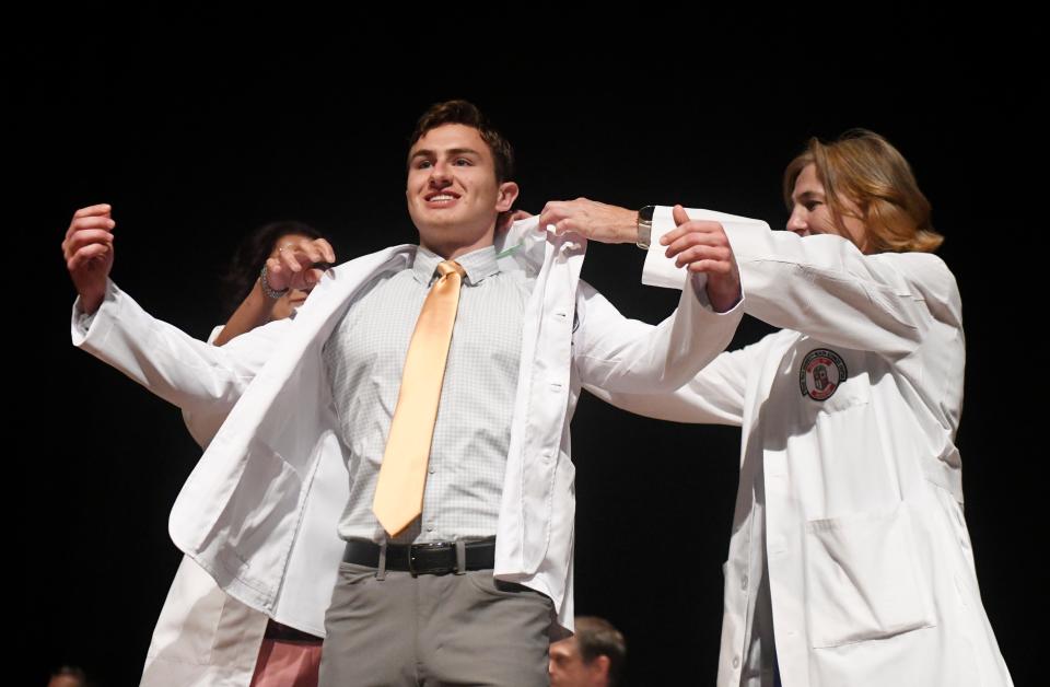 Sawyer Archer gets his white coat during the Texas Tech University Health Sciences Center School of Medicine's ceremony, Friday, July 28, 2023, at the Lubbock Memorial Civic Center.