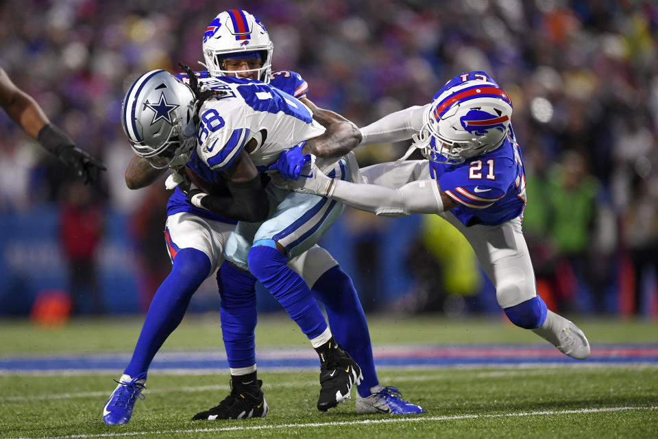 Dallas Cowboys wide receiver CeeDee Lamb (88) is tackled buy Buffalo Bills safety Jordan Poyer (21) and safety Damar Hamlin (3) during the second quarter of an NFL football game, Sunday, Dec. 17, 2023, in Orchard Park, N.Y. (AP Photo/Adrian Kraus)