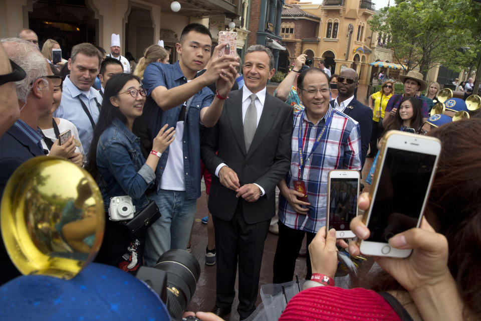 FILE - In this Thursday, June 16, 2016, file photo, Disney CEO Bob Iger poses for selfies with visitors on the opening day of the Disney Resort in Shanghai, China. On Thursday, March 23, 2017, The Walt Disney Co. announced that Iger is getting a one-year contract extension, to July 2, 2019. (AP Photo/Ng Han Guan, File)