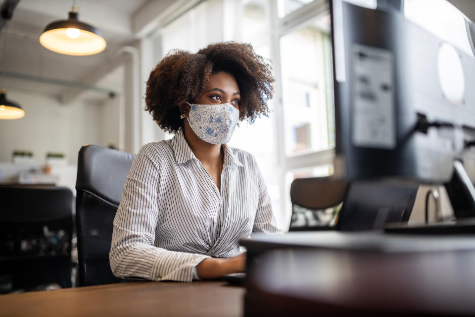 Woman working from home during coronavirus with face mask while bruxism rises