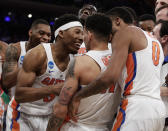 Florida players celebrate after a last second shot by guard Chris Chiozza (11) to beat Wisconsin in overtime of an East Regional semifinal game of the NCAA men's college basketball tournament, Saturday, March 25, 2017, in New York. Florida won 84-83. (AP Photo/Frank Franklin II)