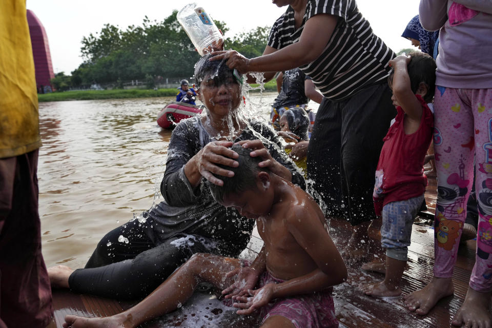 People bathe in the Cisadane River, ahead the holy fasting month of Ramadan in Tangerang, Indonesia, Tuesday, March 21, 2023. Muslims followed local tradition to wash in the river to symbolically cleanse their soul prior to entering the holiest month in Islamic calendar. (AP Photo/Tatan Syuflana)