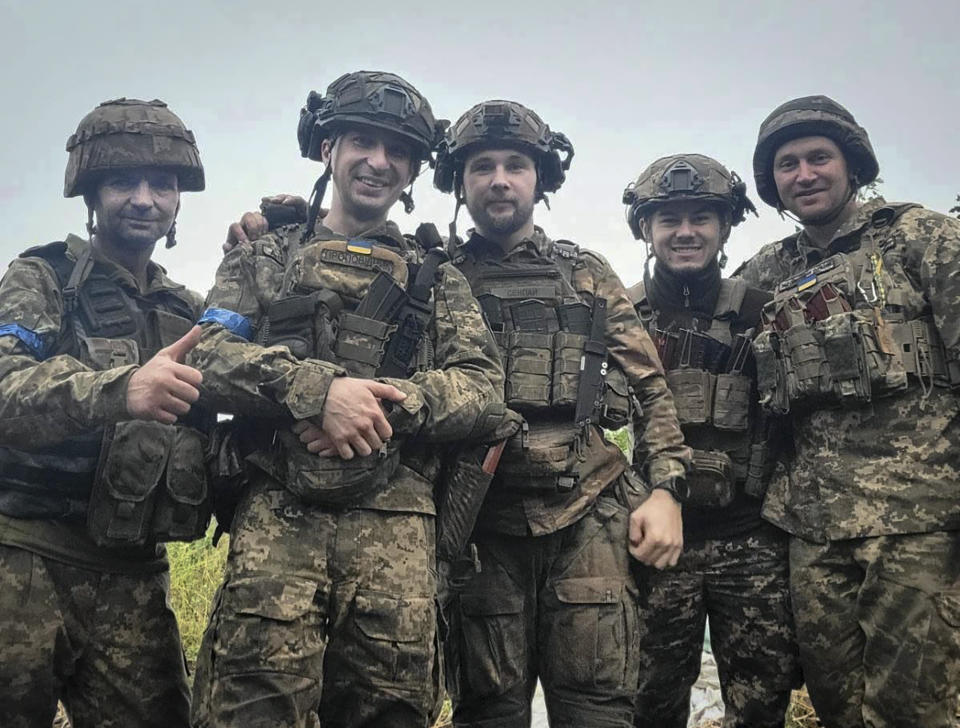 In this undated photo taken on the front-line, provided by Viktor Biliak, a Ukrainian infantryman with the 110th brigade, center, surrounded by fellow soldiers, poses for a photo, in Avdiivka, Donetsk region, Ukraine. The loss of the city of Avdiivka in February 2024 marked the end of a long, exhausting defense for the Ukrainian military. One brigade had defended the same block of buildings for months without a break. Another unit had been in the city for nearly two years. (Viktor Biliak via AP)