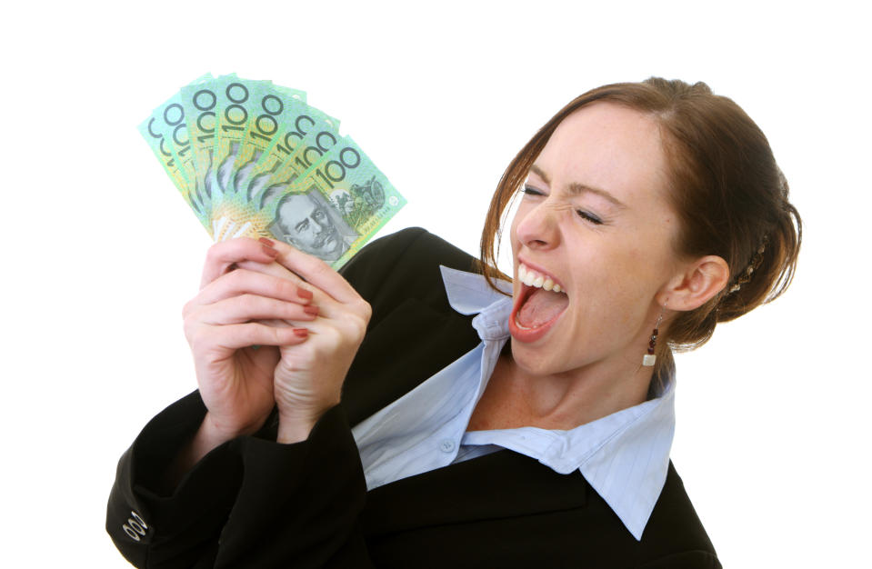 Woman with an excited expression holding Australian money.