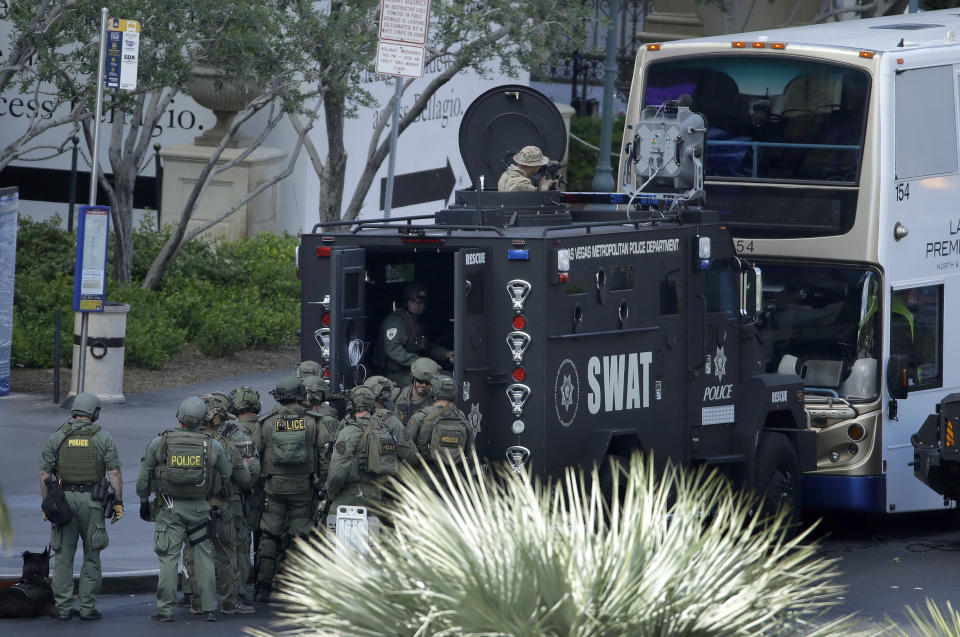 Las Vegas SWAT officers surround a bus along Las Vegas Boulevard, Saturday, March 25, 2017, in Las Vegas. Police say part of the Strip has been closed down after a shooting. (AP Photo/John Locher)