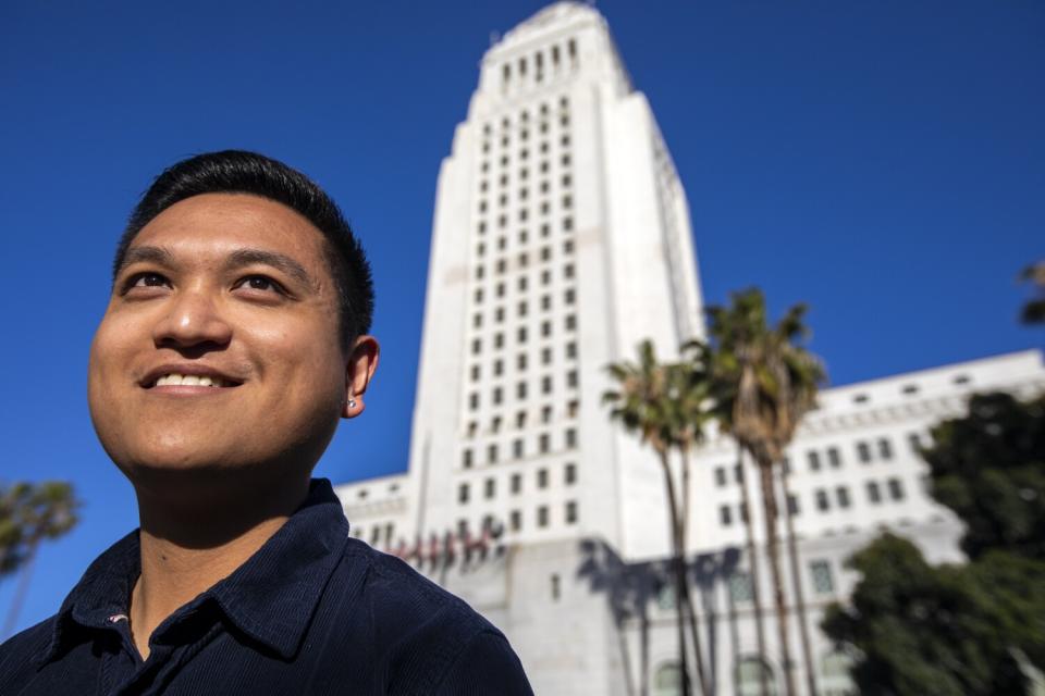 A man stands outside L.A. City Hall.