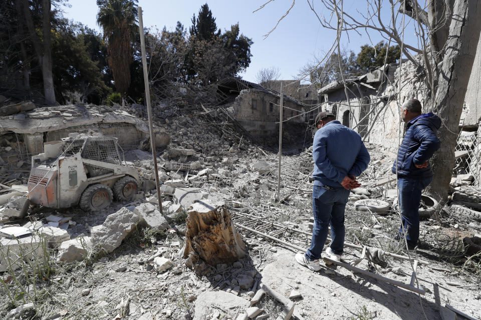 People inspect the damage of a medieval citadel after an early morning Israeli airstrike in the capital city of Damascus, Syria, Sunday, Feb. 19, 2023. Syrian state news reported that Israeli airstrikes have targeted a residential neighborhood in central Damascus. (AP Photo/Omar Sanadiki)