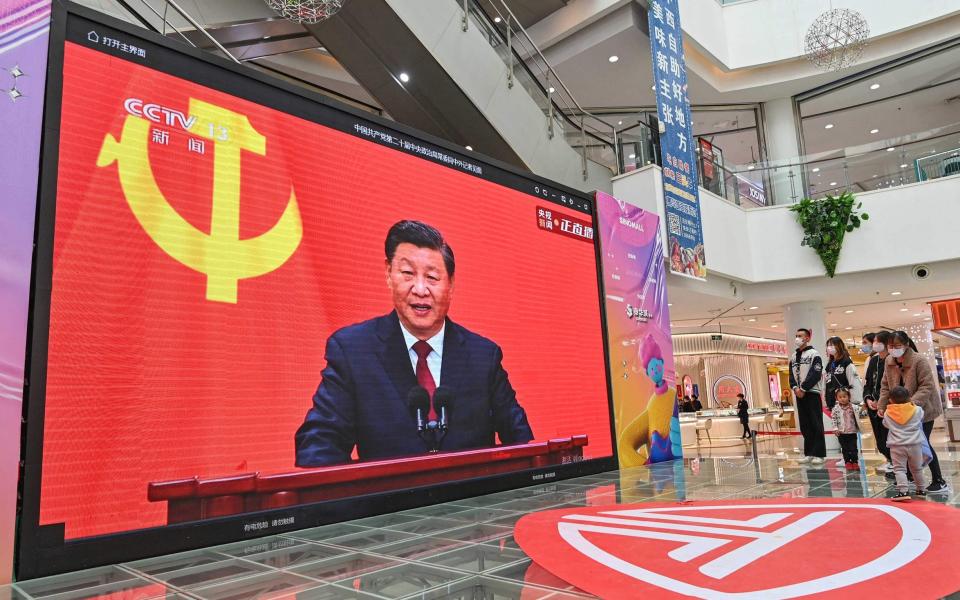 People watch a live broadcast of China's President Xi Jinping - STR/AFP 