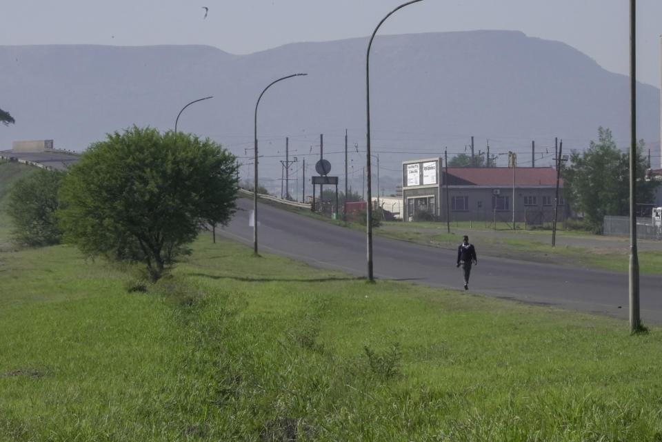A lone learner walks to school in Dundee, South Africa, Friday, Oct. 27, 2023. Thousands of children in South Africa's poorest and most remote rural communities still face a miles-long walk to school, nearly 30 years after the country ushered in democratic change. (AP Photo/ Sebabatso Mosamo)