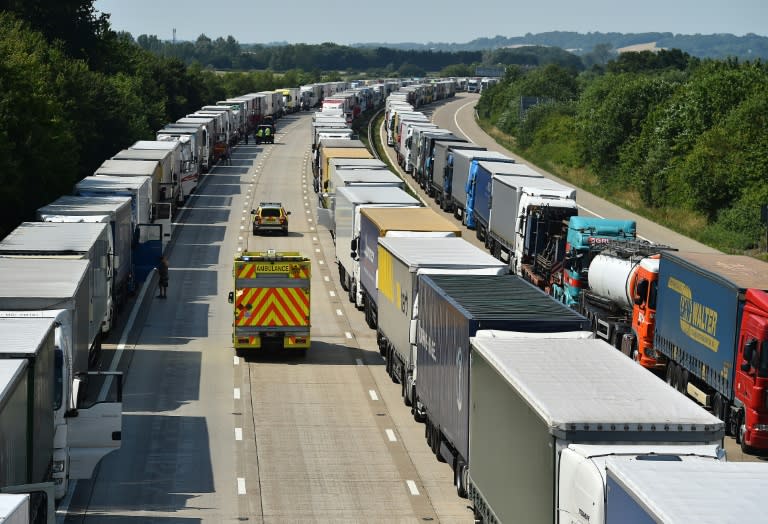 Emergency vehicles patrol between hundreds of parked trucks on the M20 motorway near Ashford in Kent, south-east England, on July 1, 2015 as they wait to board ferries to France as striking ferry workers blocked the port of Calais