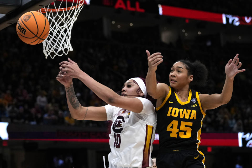 South Carolina center Kamilla Cardoso (10) fights for a rebound with Iowa forward Hannah Stuelke (45) during the first half of the Final Four college basketball championship game in the women's NCAA Tournament, Sunday, April 7, 2024, in Cleveland. (AP Photo/Carolyn Kaster)