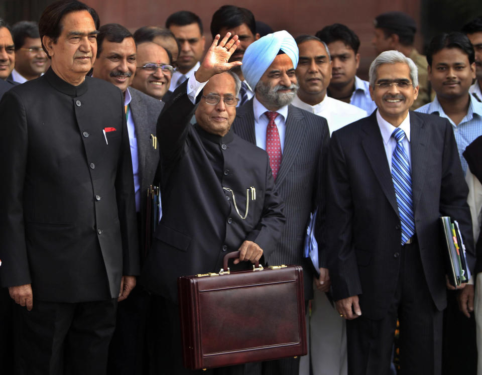 Indian Finance Minister Pranab Mukherjee, center, holds a briefcase containing the annual budget documents as he leaves for the Indian Parliament, in New Delhi, India, Friday, March 16, 2012. Mukherjee presented India's new budget Friday amid concerns about inflation, the country's falling growth rate and its large deficit. (AP Photo/Mustafa Quraishi)