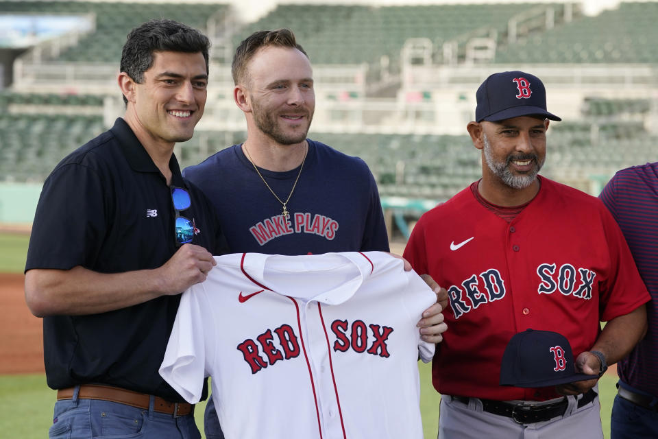 New Boston Red Sox shortstop Trevor Story, center, holds a jersey as manager Alex Cora, right, and Chief Baseball Officer Chaim Bloom, left, join in during a baseball press conference at JetBlue Park Wednesday, March 23, 2022, in Fort Myers, Fla. (AP Photo/Steve Helber)