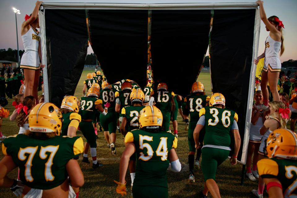 Yulee's Braylen Crowder (77), Jalen McGraw (54) and Braiden Shiver (36) run onto the field before an Oct. 13 game against Baker County.