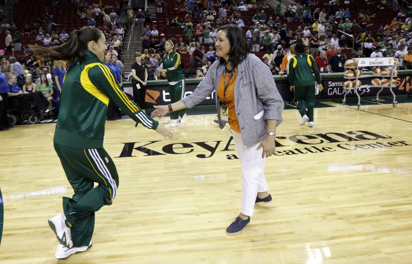 Outgoing Seattle Storm CEO and president Karen Bryant, right, is greeted by Sue Bird as Bryant is honored on her last day before a WNBA basketball game between the Storm and Indiana Fever Thursday, July 31, 2014, in Seattle. (AP Photo/Elaine Thompson)