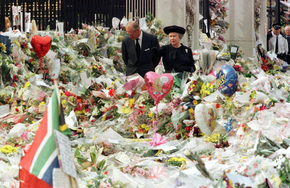 FILE - Britain's Queen Elizabeth II and Prince Philip view the floral tributes to Diana, Princess of Wales, at London's Buckingham Palace, Friday, Sept. 5, 1997. Above all, there was shock. That’s the word people use over and over again when they remember Princess Diana’s death in a Paris car crash 25 years ago this week. The woman the world watched grow from a shy teenage nursery school teacher into a glamorous celebrity who comforted AIDS patients and campaigned for landmine removal couldn’t be dead at the age of 36, could she? (Pool Photo via AP, File)