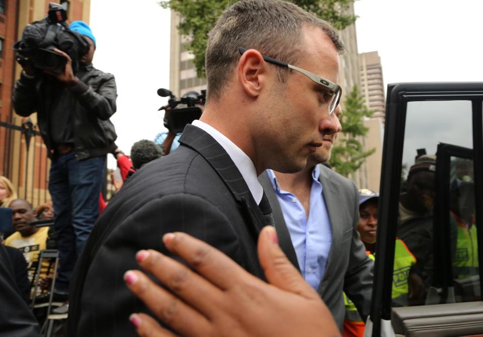 Oscar Pistorius, with unidentified relative leaves the high court in Pretoria, South Africa, Thursday, April 17, 2014. One of Oscar Pistorius’ defense experts was grilled by the chief prosecutor for the second day at the Olympic runner’s murder trial Thursday, with forensic specialist Roger Dixon’s expertise and professionalism in conducting various tests regarding Reeva Steenkamp’s shooting death again sternly questioned. Pistorius is charged with premeditated murder for shooting Steenkamp multiple times on Feb. 14, 2013. Prosecutors say that he killed Steenkamp after a fight. The trial was adjourned until May 5. (AP Photo/Themba Hadebe)