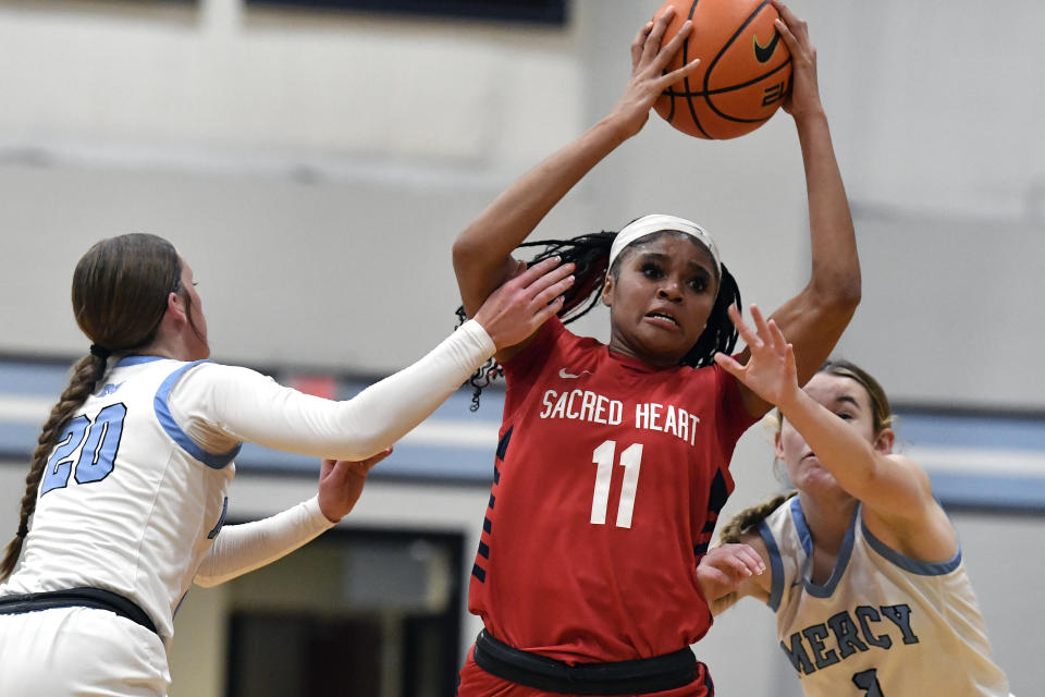 Sacred Heart Academy guard ZaKiyah Johnson is double-teamed during a high school basketball game against Mercy Academy in Louisville, Ky., Sunday, Feb. 11, 2024. The junior wing ranked as a top prospect for next season has pared her initial list down to a dozen schools, a group that includes defending national champion LSU, current No. 1 and two-time champ South Carolina, UConn and nearby Louisville. (AP Photo/Timothy D. Easley)