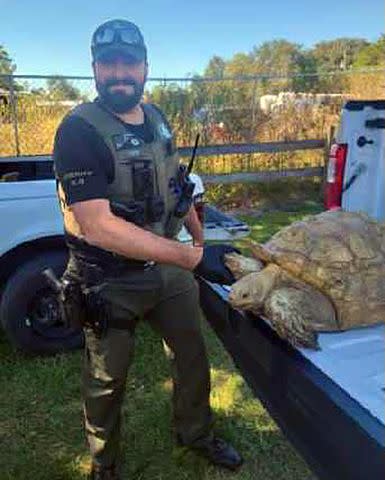 <p>Putnam County Sheriff's Office</p> A police officer with the pet tortoise, who went missing in April 2020.