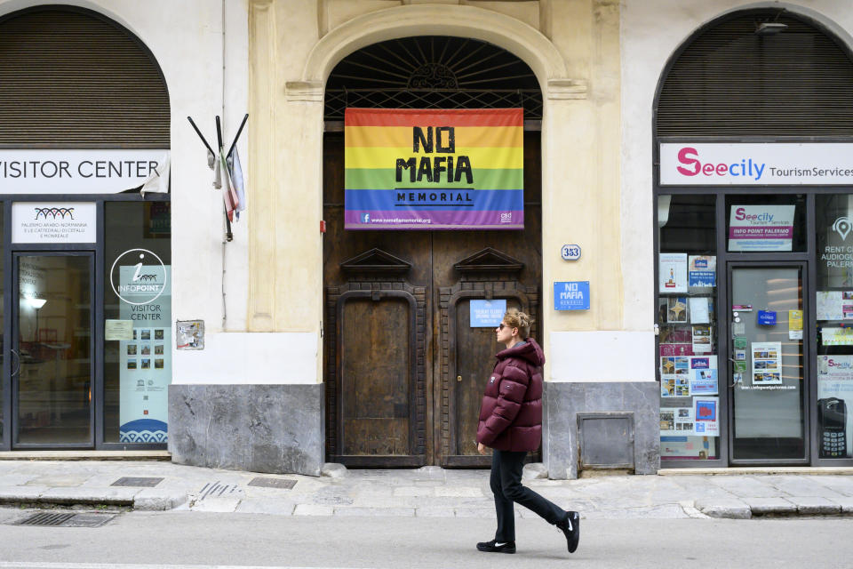 A man walks past a flag that reads: "No Mafia" in Palermo, Italy, Tuesday Jan. 17, 2023. Italy's No. 1 fugitive, Mafia boss Matteo Messina Denaro, was arrested Monday after 30 years on the run. Matteo Messina Denaro's long record as a killer — turncoat mobsters said he'd boast of enough murders to fill a cemetery — greatly burnished his credentials among his peers as a major boss in the Sicilian Mafia.(AP Photo/Valeria Ferraro)