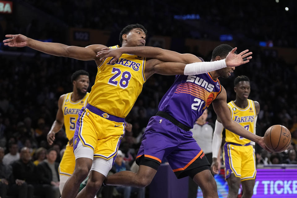 Los Angeles Lakers forward Rui Hachimura, left, and Phoenix Suns forward T.J. Warren reach for a rebound during the first half of an NBA basketball game Wednesday, March 22, 2023, in Los Angeles. (AP Photo/Mark J. Terrill)