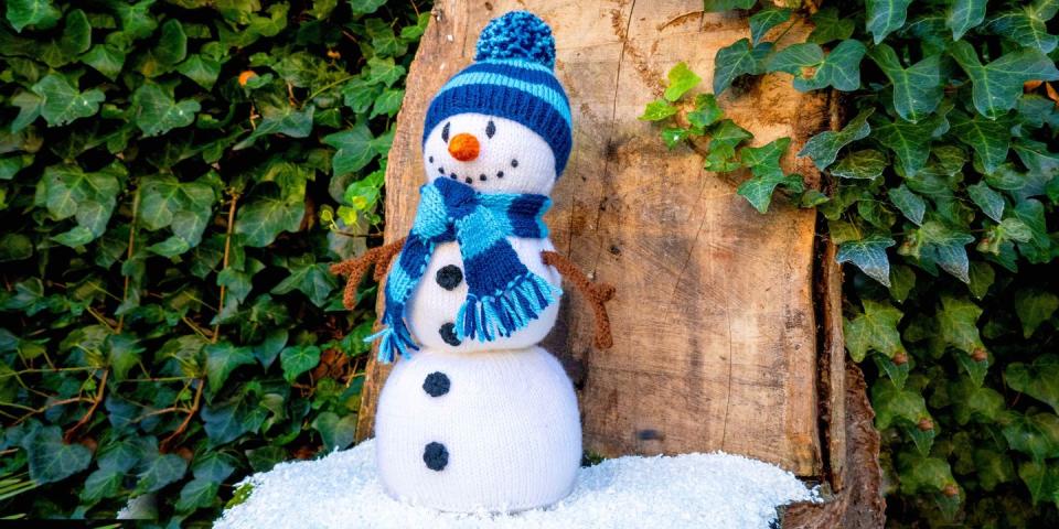 a knitted snowman with a blue hat and scarf