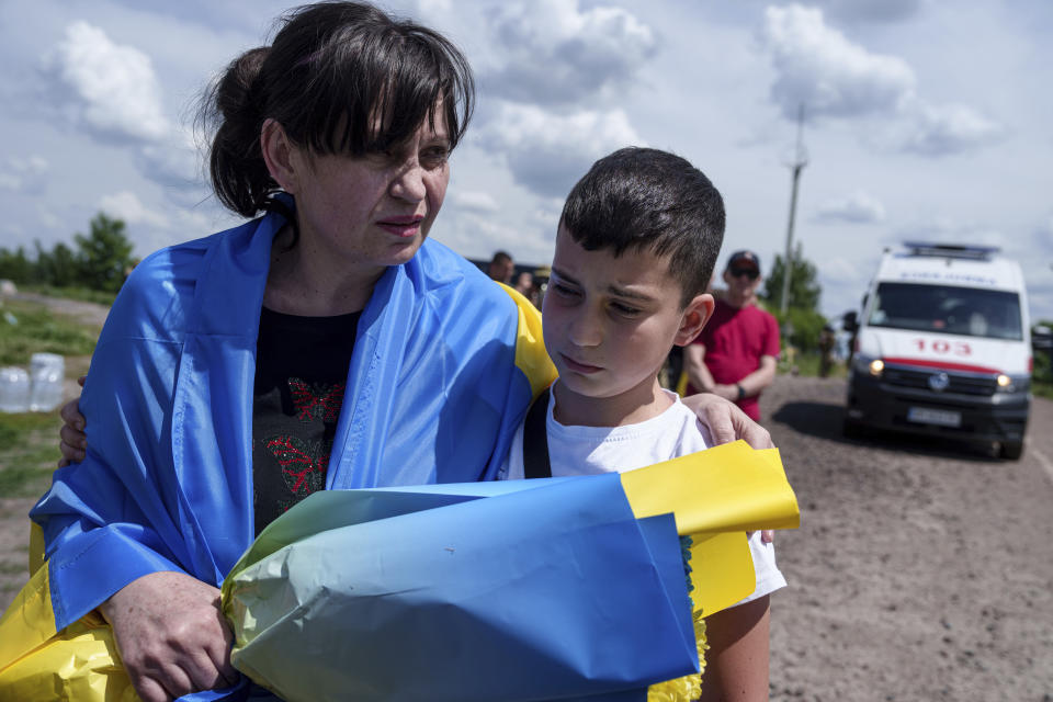 Natalia Manuilova, 44, cook of Azov brigade hugs her son Dmytro after returning from captivity during POWs exchange in Sumy region, Ukraine, Friday, May 31, 2024. Ukraine returned 75 prisoners, including four civilians, in the latest exchange of POWs with Russia. It's the fourth prisoner swap this year, and 52nd since Russia invaded Ukraine. In all, 3 210 Ukrainian servicemen and civilians were returned since the outbreak of the war. (AP Photo/Evgeniy Maloletka)