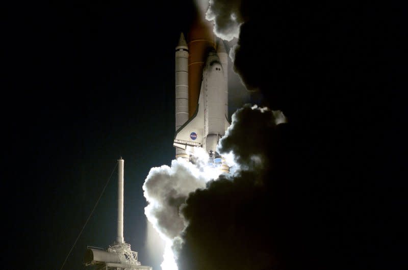 Flames from the solid rocket boosters lit up the clouds of smoke and steam trailing behind shuttle Atlantis on May 19, 2000, as it lifted off on mission STS-101. On June 29, 1995, the U.S. shuttle Atlantis docked with the Russian space station Mir for the first time. UPI File Photo