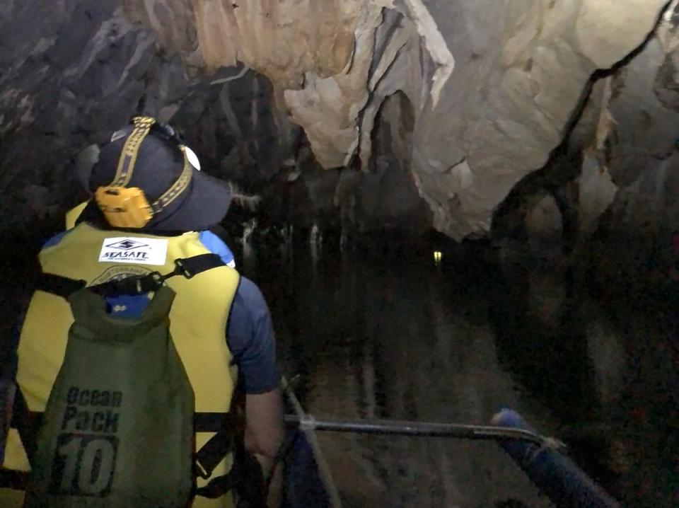 中山大學研究團隊乘坐小船進入地下河洞穴中。（圖：中山大學提供）