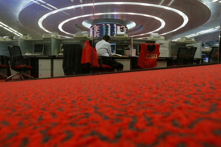 FILE PHOTO - A floor trader monitors share prices during afternoon trading at the Hong Kong Stock Exchange in Hong Kong, China September 26, 2016. REUTERS/Bobby Yip/File Photo