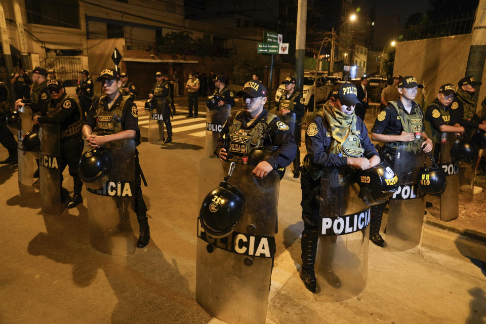 Agentes de la policía hacen guardia en el exterior de la casa de la presidenta de Perú, Dina Boluarte, durante un allanamiento para incautar relojes de lujo dentro de una investigación preliminar por presunto enriquecimiento ilícito, en Lima, Perú, el 30 de marzo de 2024. (AP Foto/Martín Mejía)