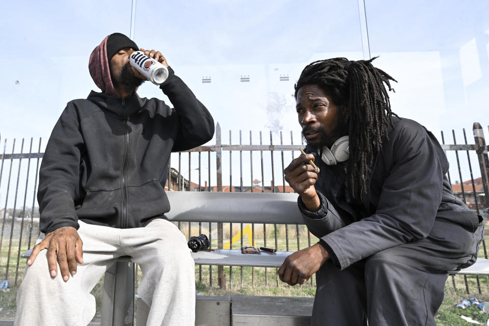 Washington, D.C. residents Randy Quander, left, drinks a beer while Mike Shaw, right, smokes a marijuana cigarette near the Entertainment and Sports Arena, Friday, March 1, 2024, in Washington. The proposed move of the Capitals and Wizards sports teams to nearby Virginia has stoked concern in a pair of fragile Washington neighborhoods. (AP Photo/Terrance Williams)