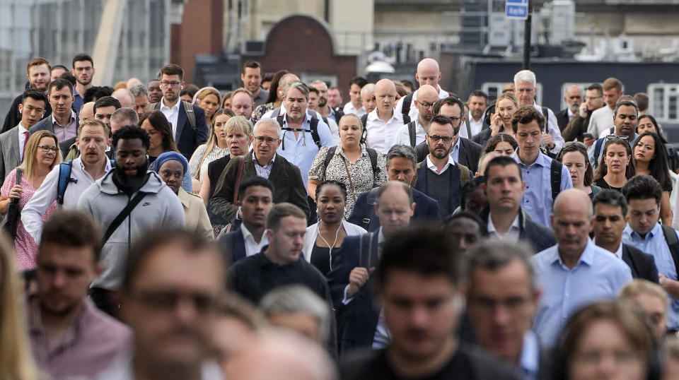 People walk over the London Bridge to work in the City of London on Monday morning, Sept. 12, 2022. (AP Photo/Martin Meissner)