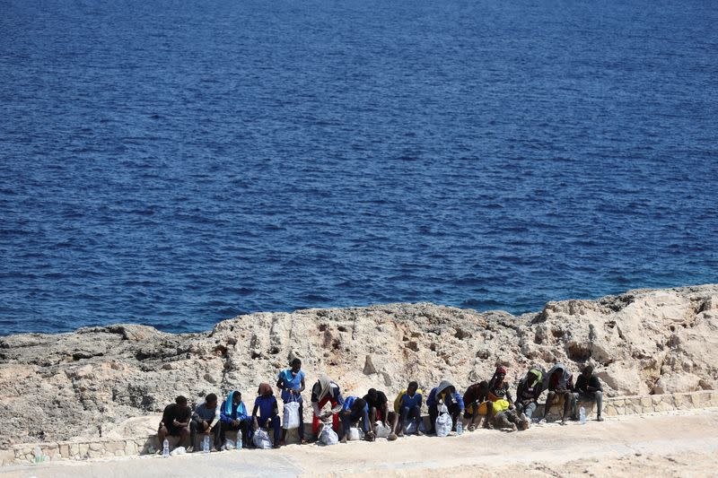 Foto del jueves de migrantes esperando cerca del puerto para ser trasladados a tierra e la isla de Lampedusa