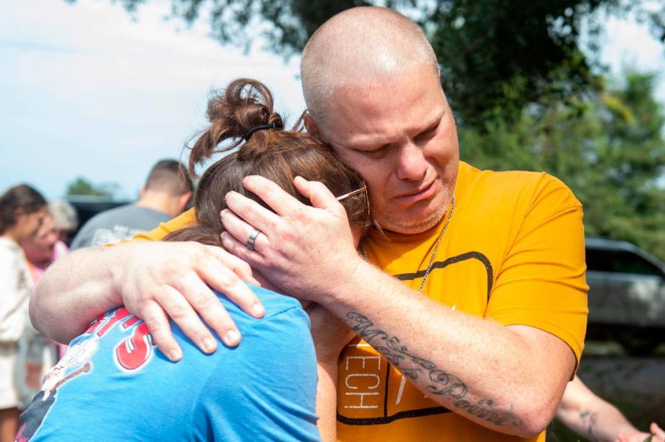 The parents of Baleigh Bowlin hug at the site of a fatal car accident that claimed the lives of their daughter and her best friend, Chloe Taylor, off of Highway 613 in Hurley on Monday, Oct. 17, 2022.