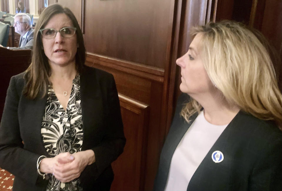 State Rep. Ann Williams, D-Chicago, discusses her abortion legislation with Rep. Terra Costa Howard, D-Glen Ellyn, on the House floor on Thursday, May 11, 2023, in Springfield, Ill. Williams is sponsoring legislation requiring other states entering compacts with Illinois over the use of automated license plate reader technology to promise not to use it to track people who might be coming to Illinois for an abortion. (AP Photo/John O'Connor).