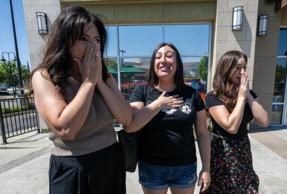 Jackie Byrd, left, and her two daughters, Erica and Christiana Sandoval, family of a Folsom police officer who died 20 years ago, react to the gift of quilts made by Jess Chairez on June 22 in Lincoln. Chairez son Joe was a Sacramento police officer, finds meaning in making quilts that feature patches from police departments around the country and donating them to families of local law enforcement officers who have died.