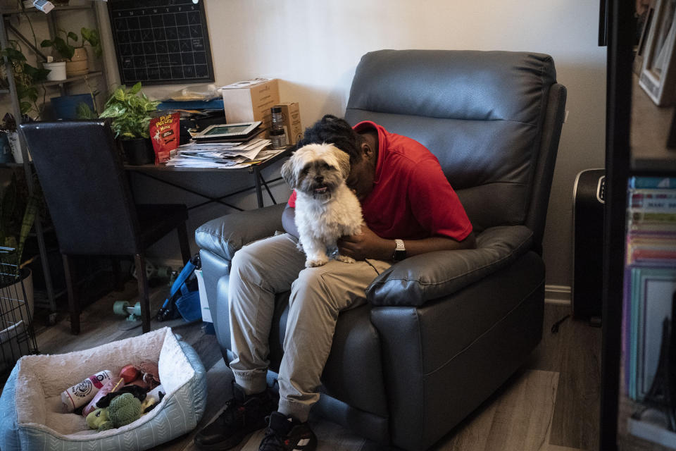Zachary Marr hugs his family's dog, Ryder, in their living room at home in District Heights, Md., on Wednesday, Sept. 21, 2022. (AP Photo/Wong Maye-E)