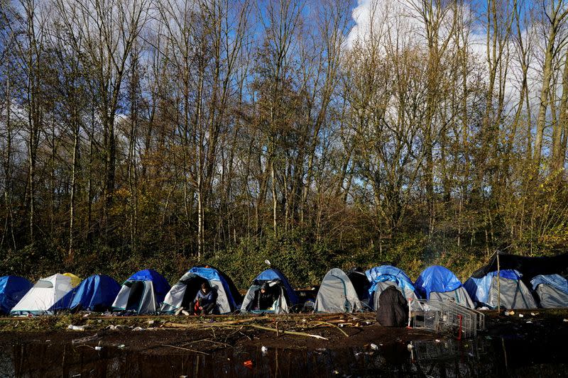 FILE PHOTO: Kurdish migrants sit at a makeshift camp in Loon-Plage near Dunkirk, France,