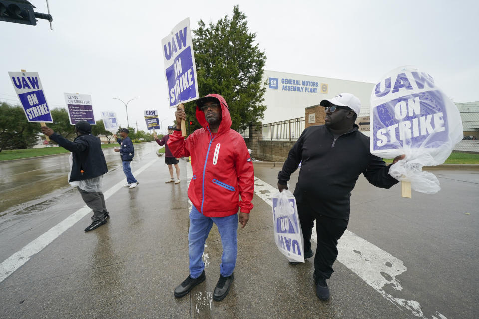 File - Picketers strike outside of the General Motors assembly plant, Tuesday, Oct. 24, 2023, in Arlington, Texas. General Motors and Jeep maker Stellantis will meet with United Auto Workers bargainers Thursday to see if they can reach a tentative contract agreement that mirrors a deal reached with crosstown rival Ford on Wednesday. (AP Photo/Julio Cortez, File)