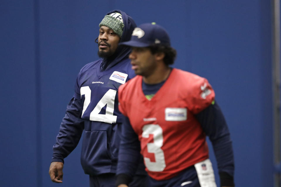 Seattle Seahawks running back Marshawn Lynch, left, looks across at quarterback Russell Wilson during warmups at the NFL football team's practice facility Tuesday, Dec. 24, 2019, in Renton, Wash. When Lynch played his last game for the Seahawks in 2016, the idea of him ever wearing a Seahawks uniform again seemed preposterous. Yet, here are the Seahawks getting ready to have Lynch potentially play a major role Sunday against San Francisco with the NFC West title on the line. (AP Photo/Elaine Thompson)